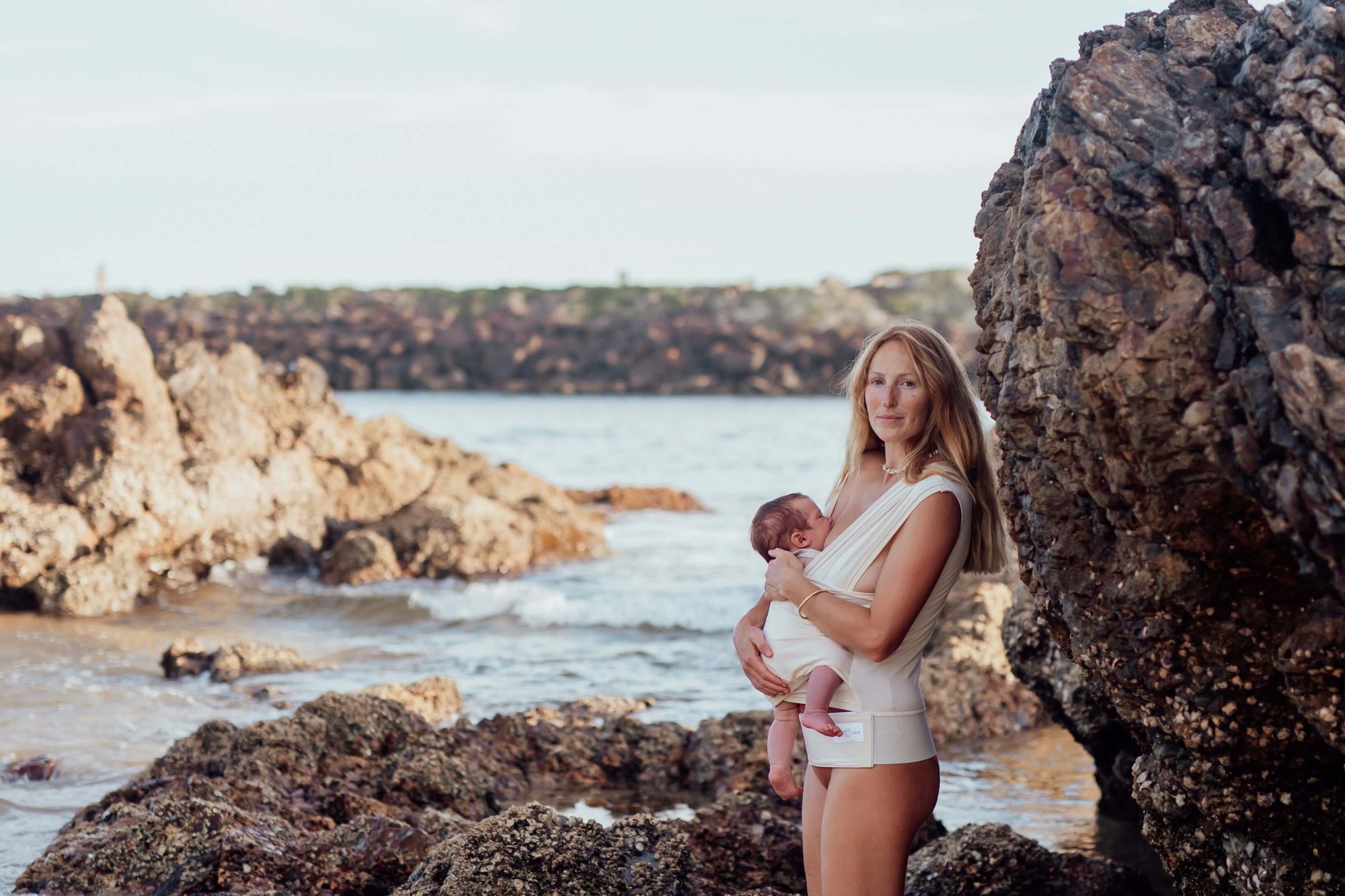 Newborn Baby Carrier in Sand Color worn by a Parent 