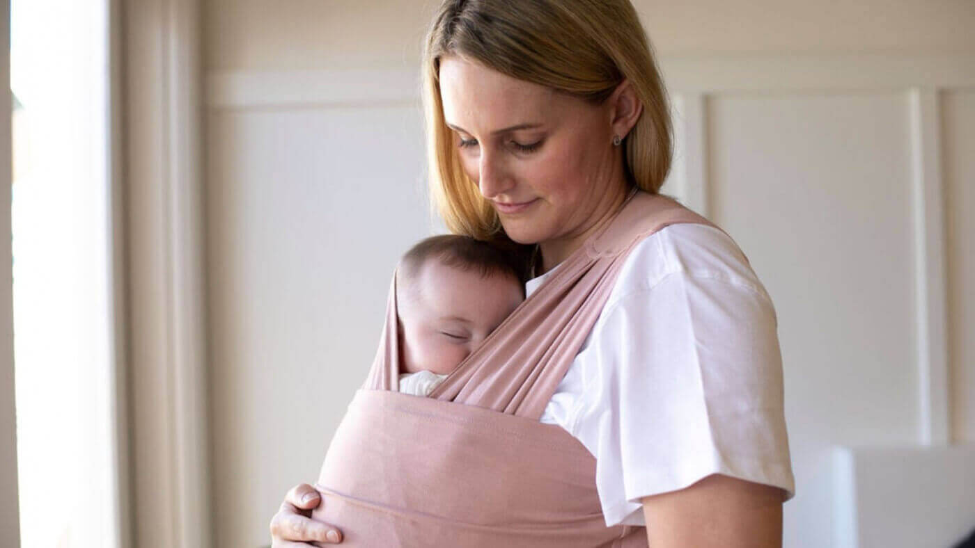 Newborn Carrier worn by a Mum in color Pink