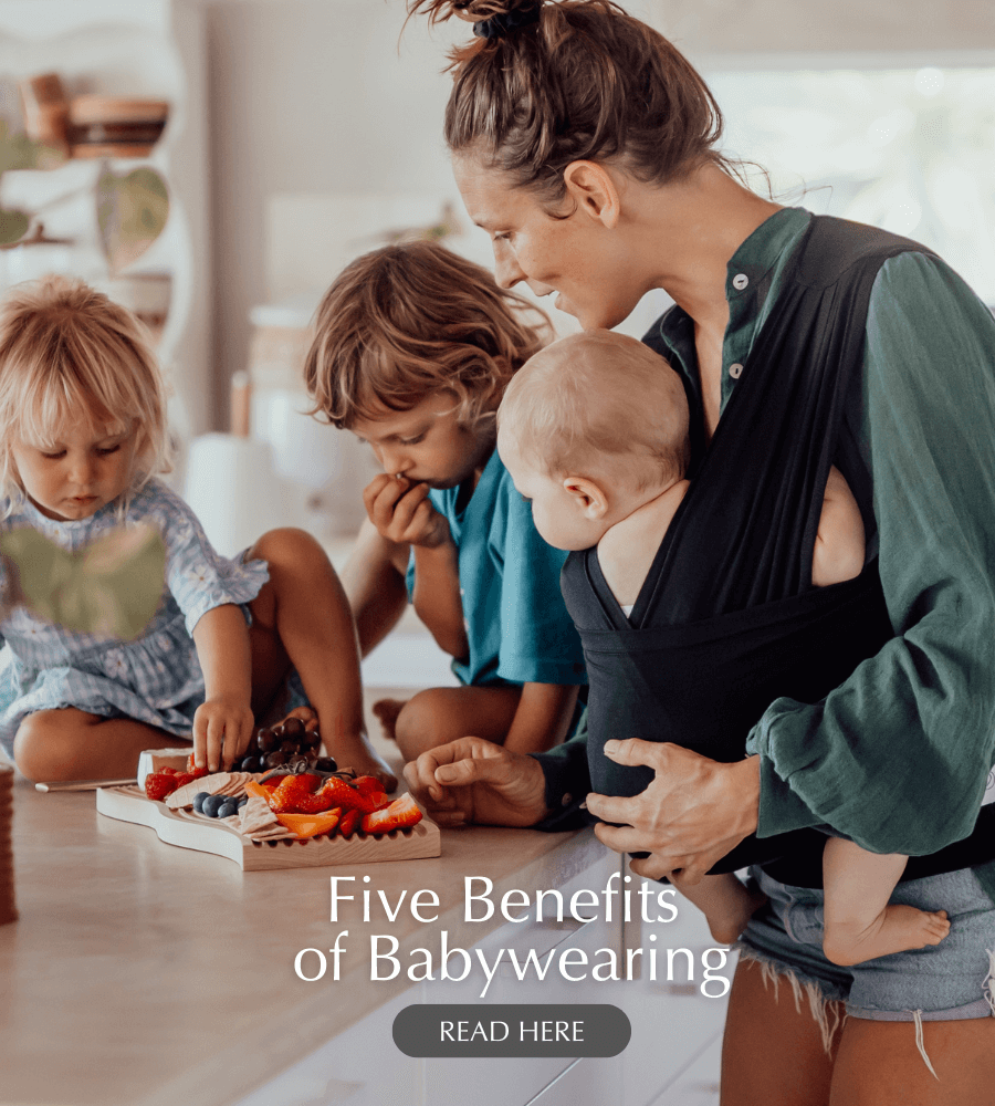 A family preparing a meal while babywearing using BabyDink Carrier