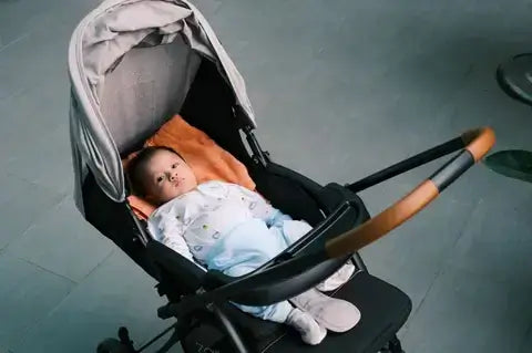 A mother adjusting her baby in a pram from Unsplash