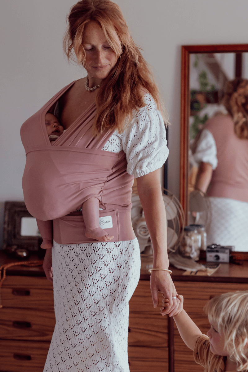 Newborn Baby Carrier in Pink Color worn by a Parent 